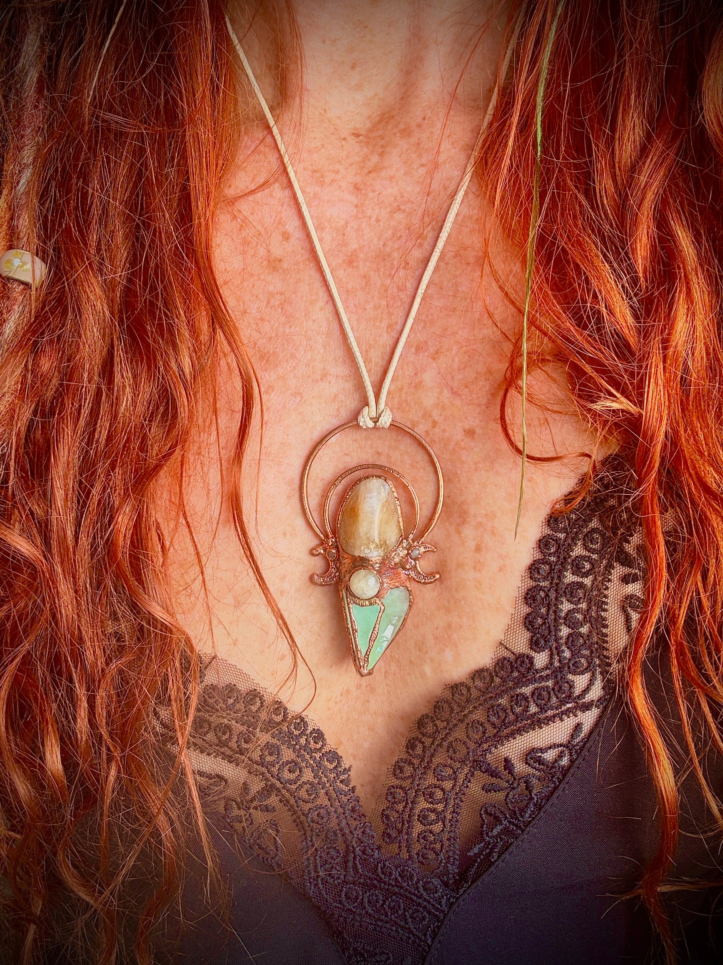 Handmade copper pendant with carnelian, green calcite, yellow jade cabochon, and crescent moons – crystal jewellery for confidence and heart healing.
