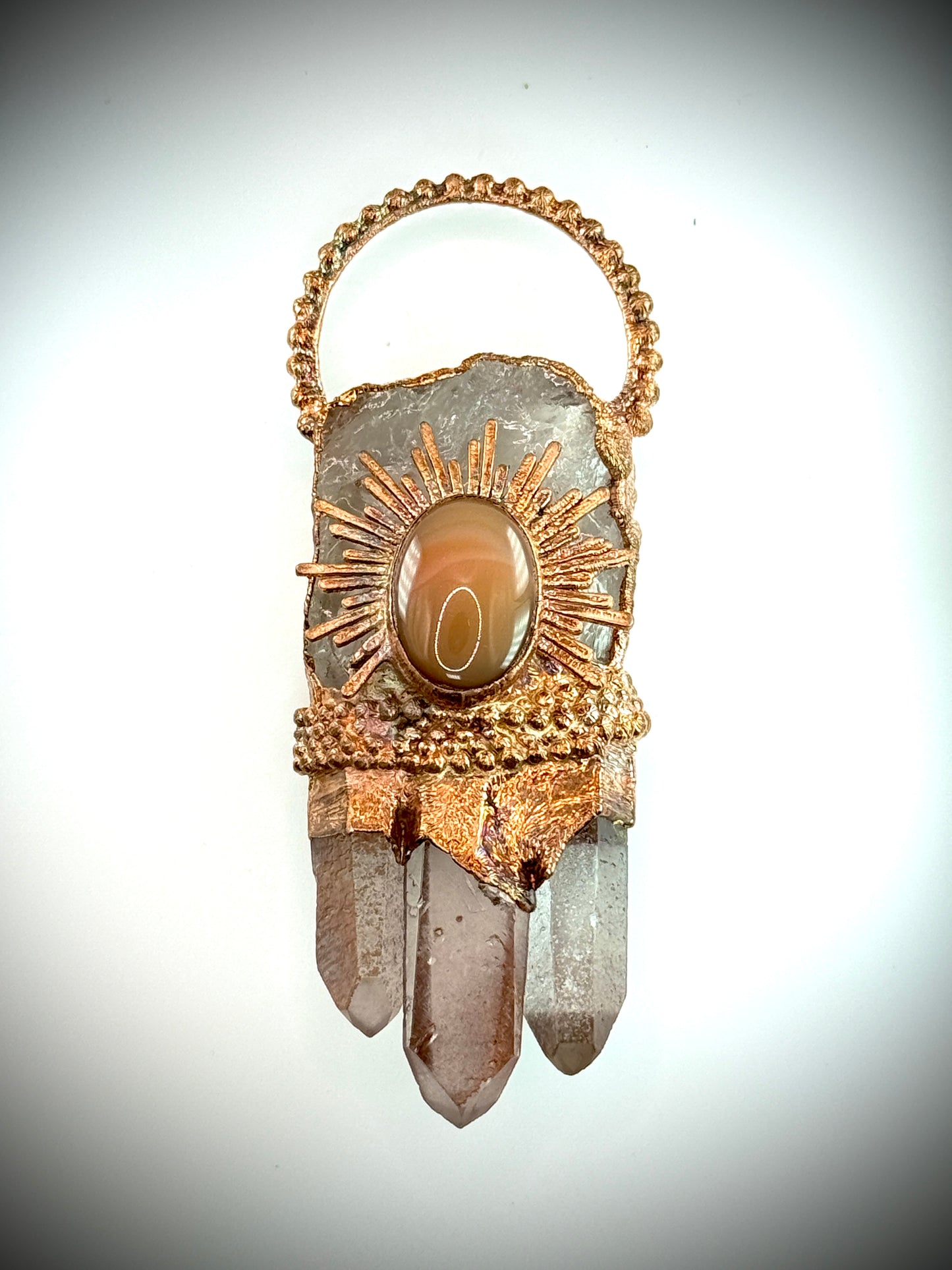 Handmade copper pendant with clear quartz crown, red lithium quartz points, carnelian cabochon, and sunburst accent – fiery crystal statement jewellery.