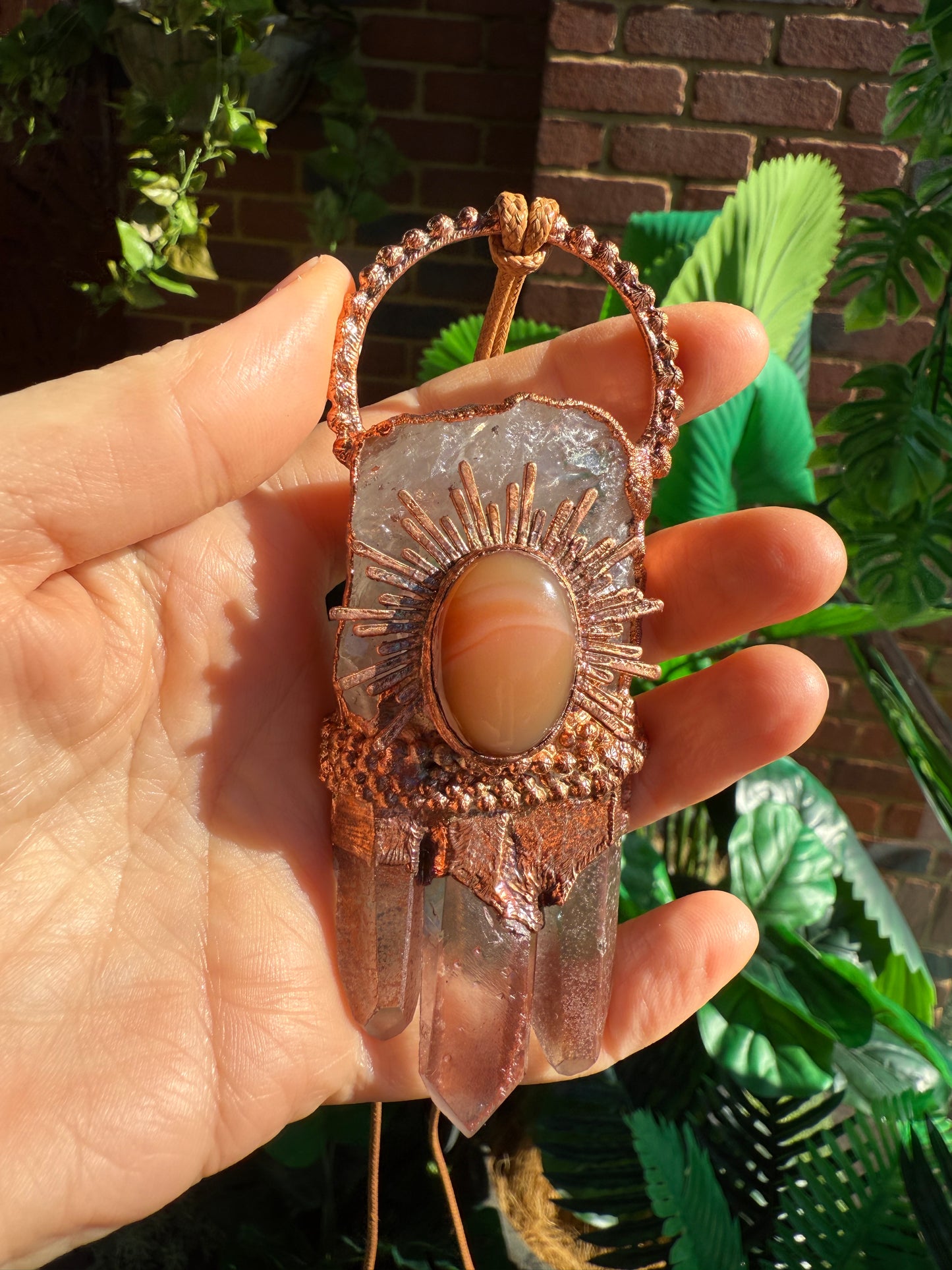 Handmade copper pendant with clear quartz crown, red lithium quartz points, carnelian cabochon, and sunburst accent – fiery crystal statement jewellery.