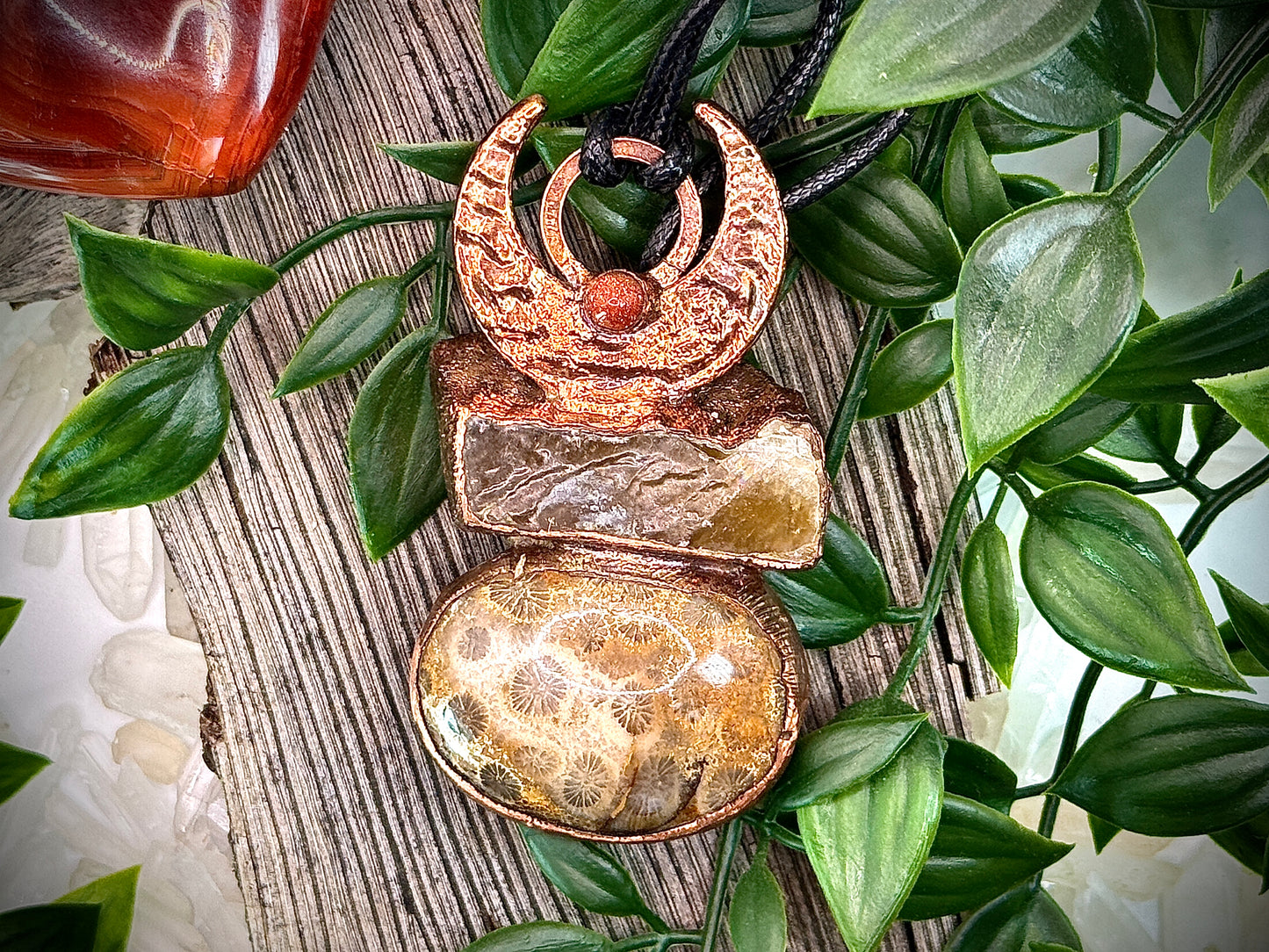 Handmade copper pendant with honey calcite, fossilized coral, goldstone, and an inverted crescent moon – earthy crystal jewellery for ambition and wisdom.