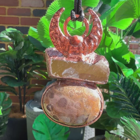 Handmade copper pendant with honey calcite, fossilized coral, goldstone, and an inverted crescent moon – earthy crystal jewellery for ambition and wisdom.