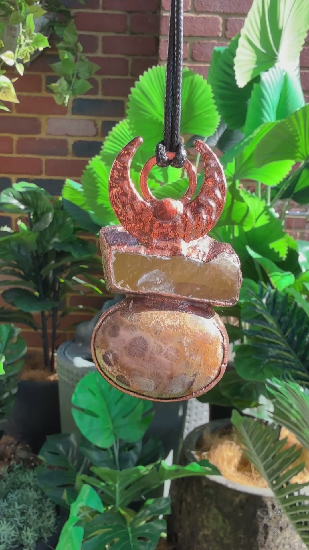 Handmade copper pendant with honey calcite, fossilized coral, goldstone, and an inverted crescent moon – earthy crystal jewellery for ambition and wisdom.